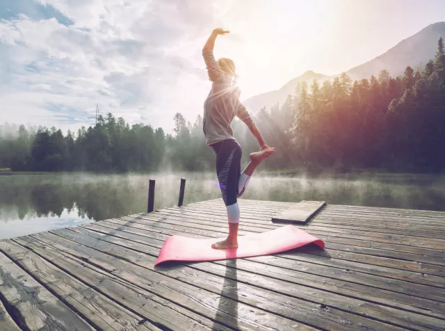 Woman doing yoga in front of a lake